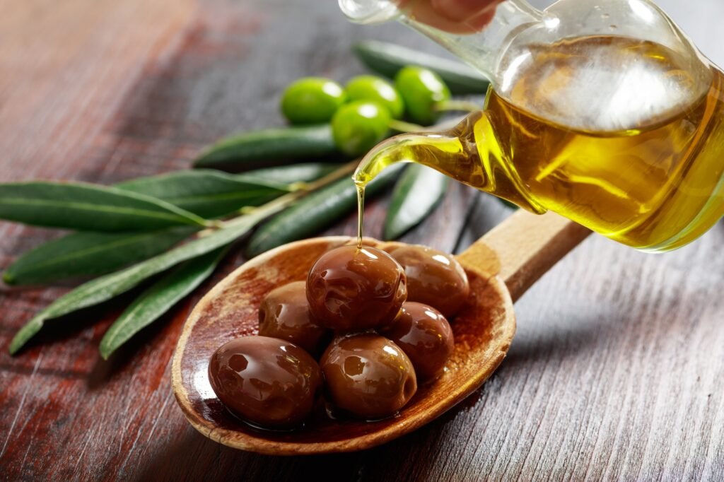 Wooden spoon with olives and olive oil